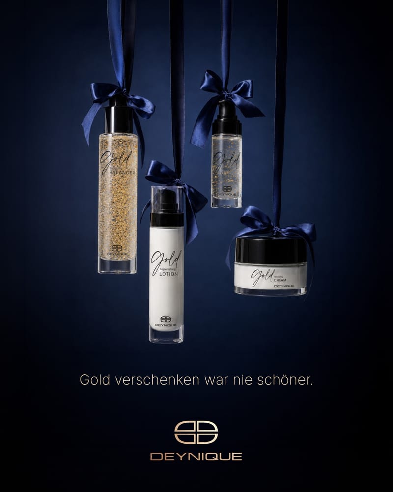 DEYNIQUE Gold-Linie: Balancer, Lotion, Öl und Creme hängen an nachtblauen Schleifen. Bildtext: Gold verschenken war nie schöner.