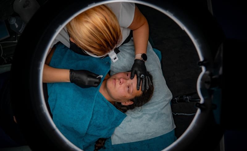Blick durchs Ringlicht: Stefanie Ernst bei der Permanent-Make-up-Arbeit